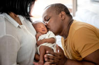 Same race adoptive parents kissing baby